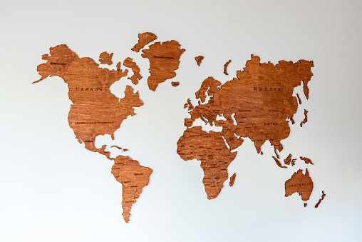 Wooden map of the world on the wall, with country names.