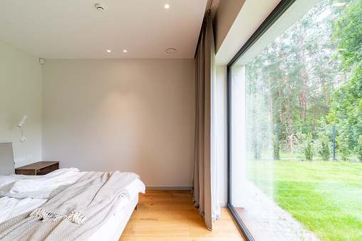 Big bed with a large window to the backyard of the house in front of it. Amazing view while waking up or going to sleep.