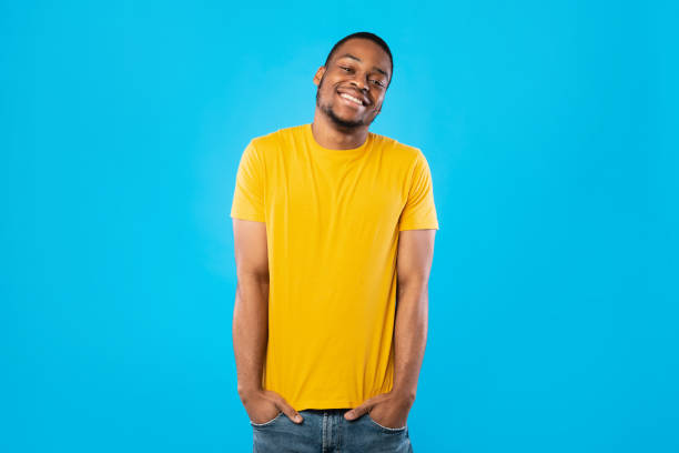 istock Happy African Man Standing Holding Hands In Pockets, Blue Background 1342243799