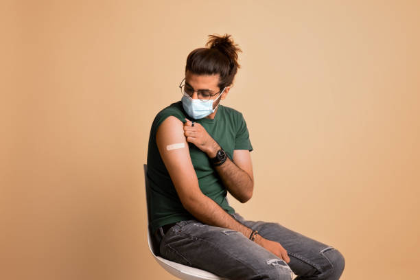 istock Middle-eastern guy in face mask looking at band on shoulder 1342244010