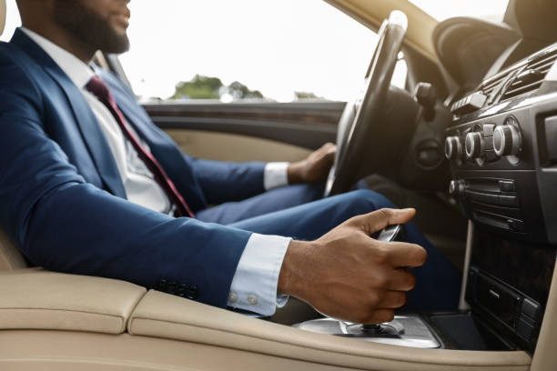 istock Unrecognizable black man in suit driving nice auto 1342244272