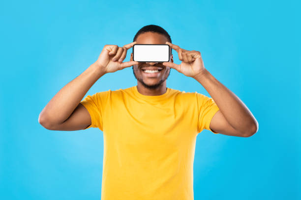 istock Black Man Holding Phone In Front Of Eyes, Blue Background 1342245108