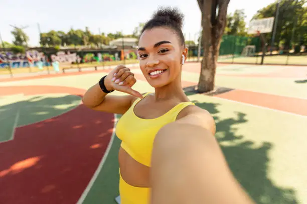 Photo of Black lady making selfie photo on smartphone during workout break