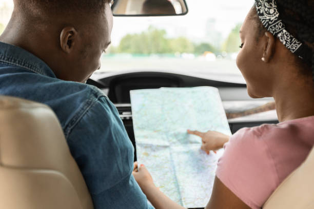 istock Black lady helping her driving boyfriend, checking map, back view 1342245306