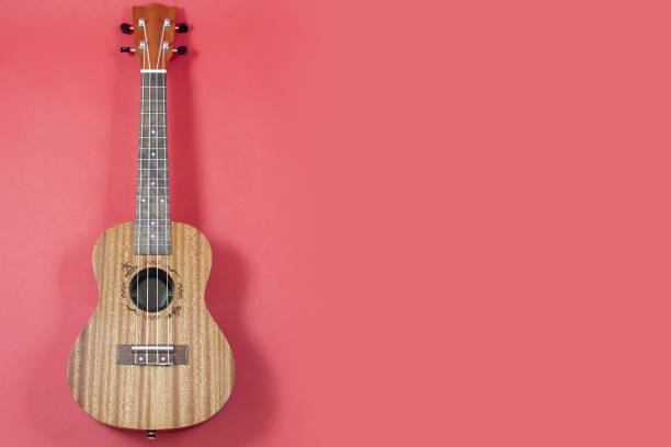istock Ukulele with copy space Christmas guitar on a red background. An invitation to 1342245331