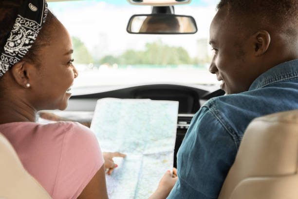 istock Afro american couple travellers looking at map while driving 1342245353