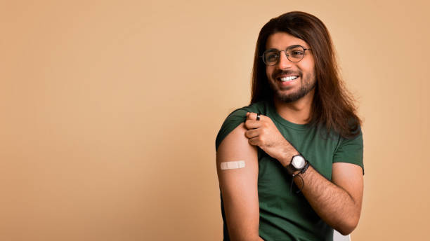 istock Happy arab guy got vaccinated, showing shoulder with plaster 1342245423