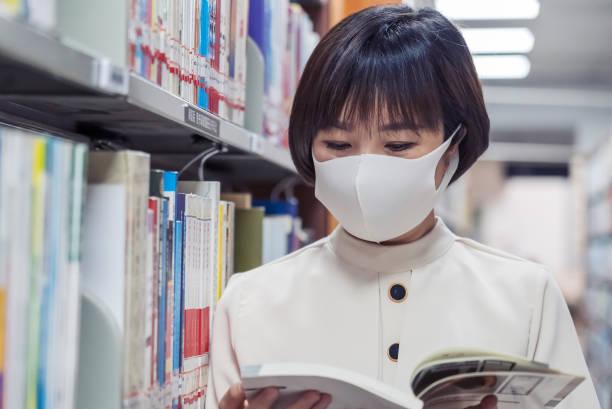 istock Asian Woman reading a book on bookshelf in the library 1342245621