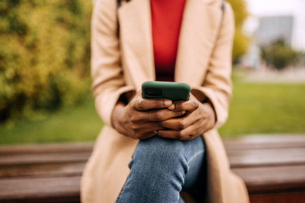 istock Unrecognisable woman using smartphone in public park 1342246840