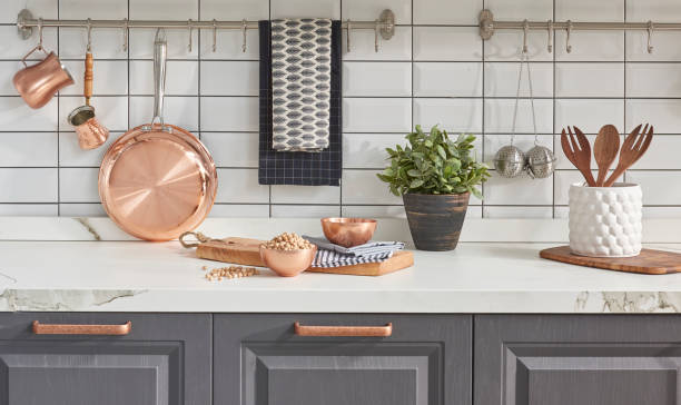 istock Kitchen brass utensils, chef accessories. Hanging copper kitchen with white tiles wall 1342247085