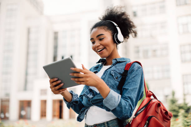 podekscytowana afroamerykańska studentka korzystająca z cyfrowego tabletu na zewnątrz - education teenagers only studying university zdjęcia i obrazy z banku zdjęć