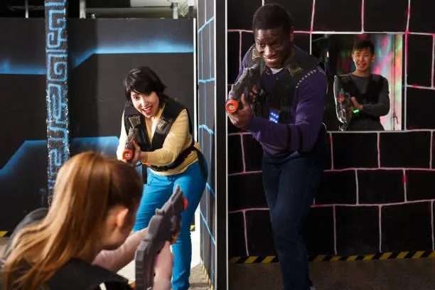 Photo of group of adult people with laser guns having fun