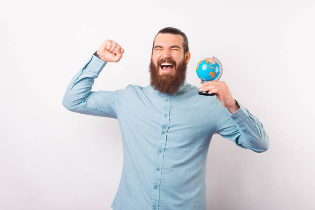 istock Bearded man has won a trip and makes the winner gesture while holding an Earth Globe. 1342248310