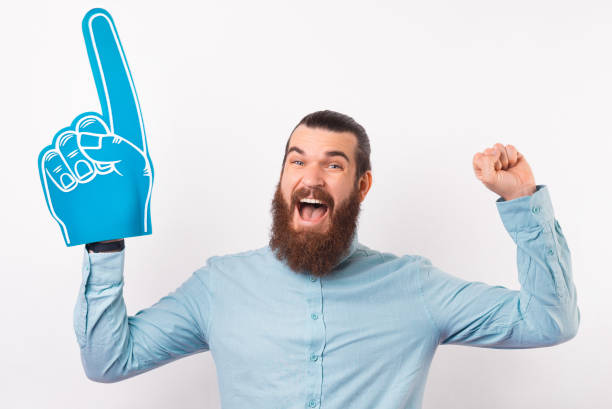 istock Excited bearded man is making the winner gesture while wearing foam fan glove. 1342248336