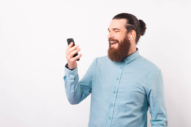 istock Happy beard man is using his phone and ear pods. 1342248345