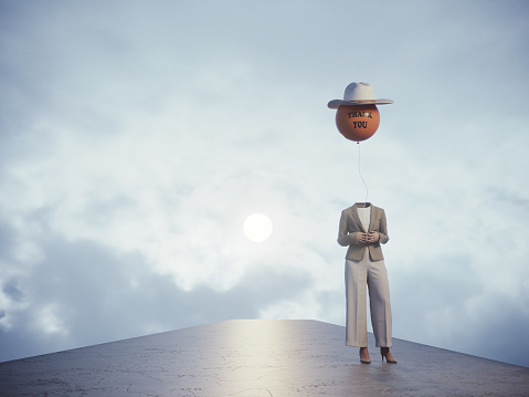 Woman without head holds orange colored smiley sphere balloon on the cloudy sky. (3d render)