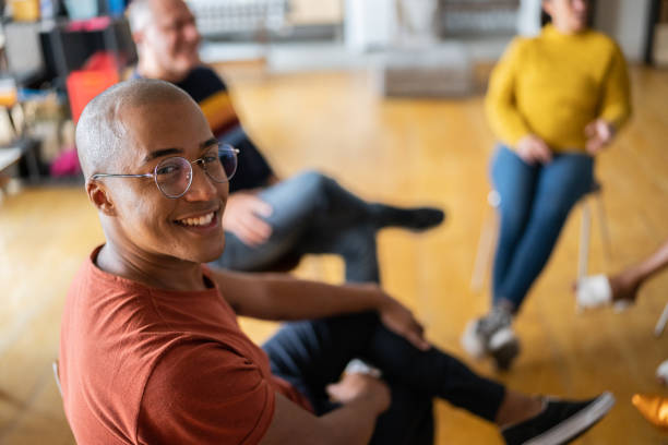 retrato de um jovem em terapia de grupo em um coworking - community center - fotografias e filmes do acervo