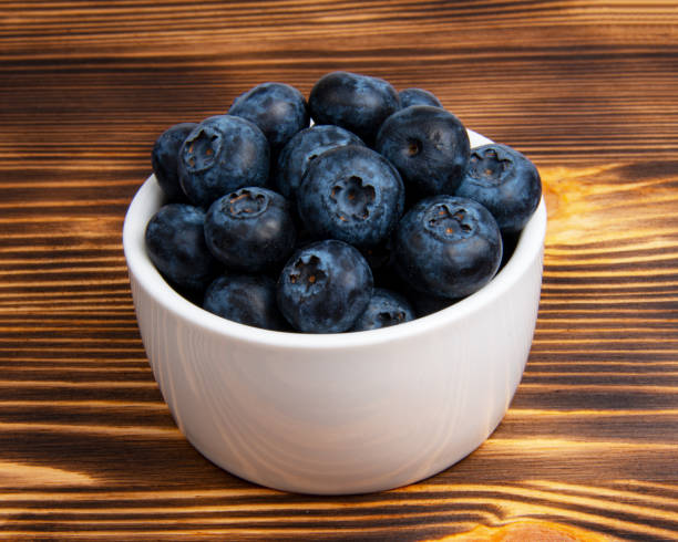 istock Fresh blueberry in white dish on wooden background 1342252111