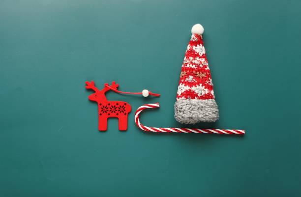 bella fotografia di natale piatta con simboli natalizi, slitta, cervo e regalo su sfondo verde - 6184 foto e immagini stock