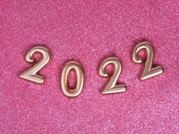 istock Bronze decorative shiny numbers 2022 new year on pink background with copy space 1342252696