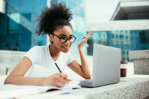 istock African Girl Using Laptop Taking Notes Watching Virtual Lecture Outdoors 1342252719