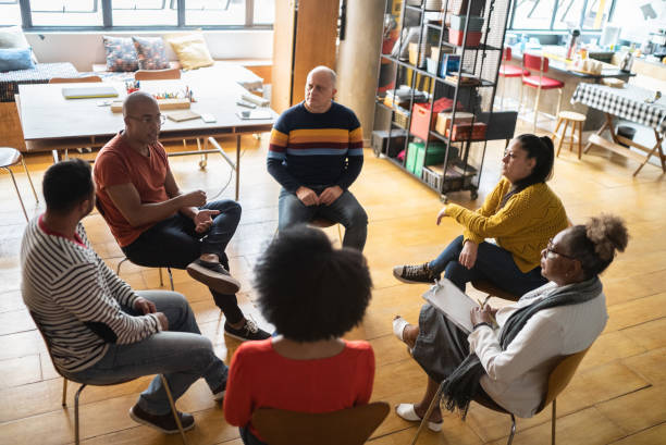 istock Young man talking in group therapy at a coworking 1342253520