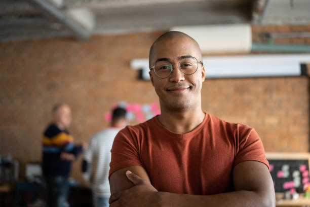 portrait of a young man at work - kaal geschoren hoofd stockfoto's en -beelden