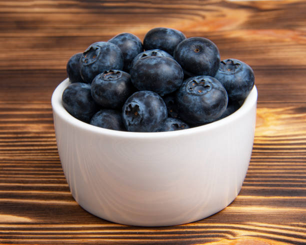istock Fresh blueberry in white dish on wooden background 1342254361