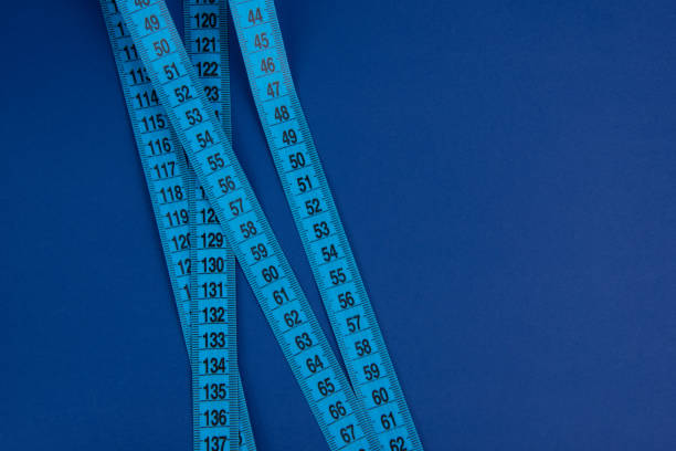 istock Blue tape measure on the bright blue background 1342254451