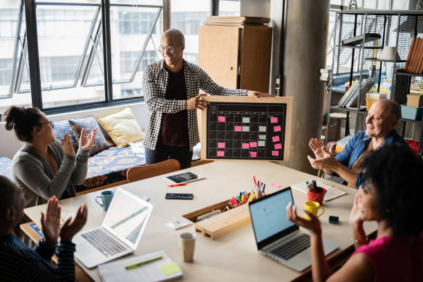 istock Young man talking and colleagues applauding in a meeting at work 1342254544