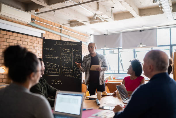 istock Young man talking in a meeting with team at work 1342255760