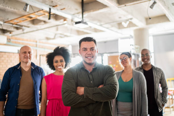 Portrait of a transgender businessman with his team at work Portrait of a transgender businessman with his team at work transgender person in office stock pictures, royalty-free photos & images