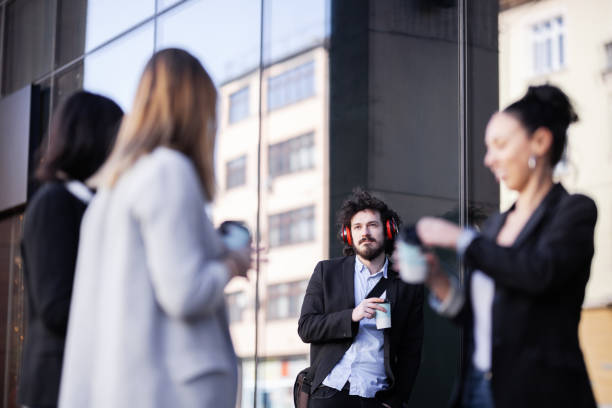 istock Business people on a coffe break outdoors. Girls gossping the man standing behind them.. 1342261701