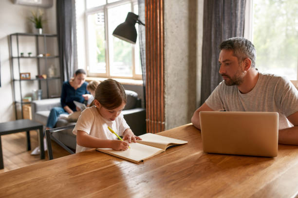 Caring father watch little daughter doing homework stock photo