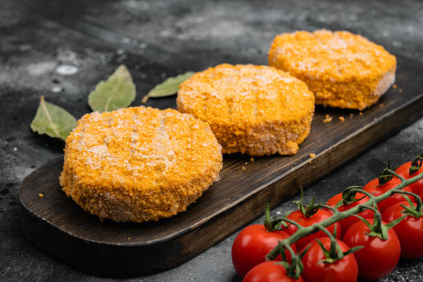 istock Frozen Breaded fish patties, on black dark stone table background 1342265199