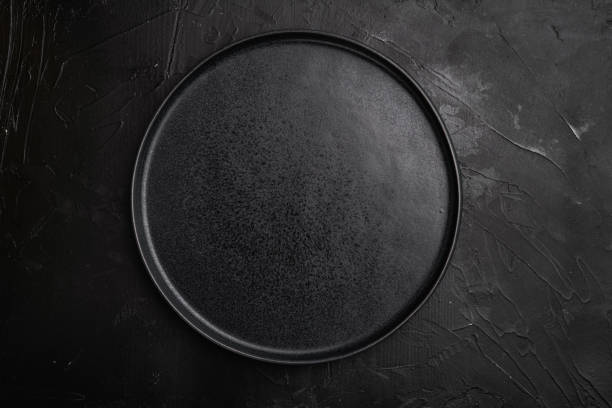 istock Top view of black plate, on black dark stone table background 1342265519