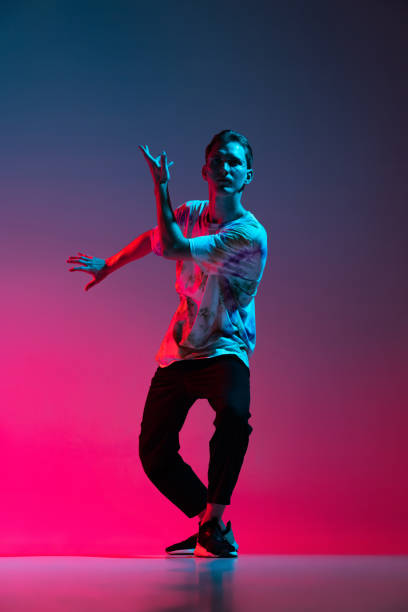 istock Vertical portrait of dynamic hip-hop dancer practising isolated over gradient pink purple background in neon light 1342265652