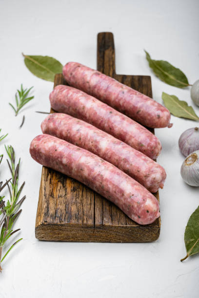 istock Raw sausage for frying, on white stone table background 1342265782