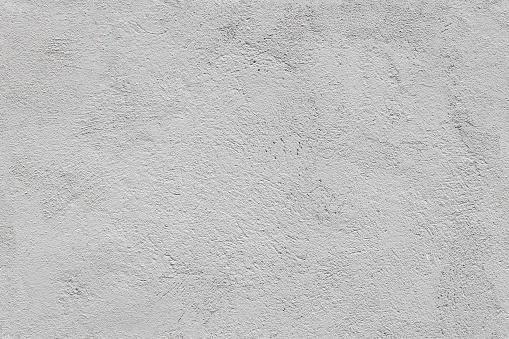 seamless texture and full frame background of rough grey plaster finish of an outdoor building wall