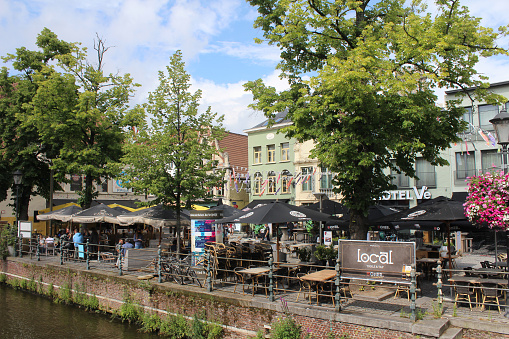 Mechelen, Belgium, 1 August 2021: View of the 'Vismarkt' (Fish Market) in Mechelen. A very popular part of the city for food and drink, with many restaurants and cafes next to the river.
