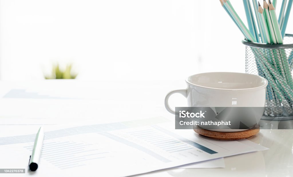 Closeup white cup and paperwork with copy space. Cup Stock Photo