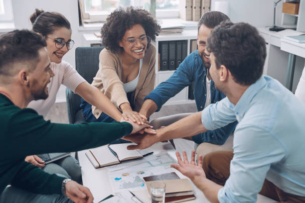 istock Confident young business team keeping hands clasped and smiling 1342270425