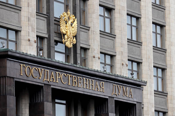 Emblem of Russia and inscription "State Duma" on facade of Russian Parliament building stock photo