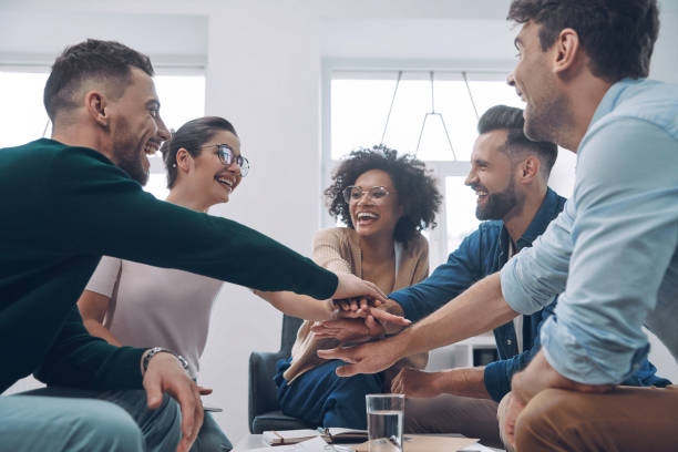 istock Confident young business team keeping hands clasped and smiling 1342270723