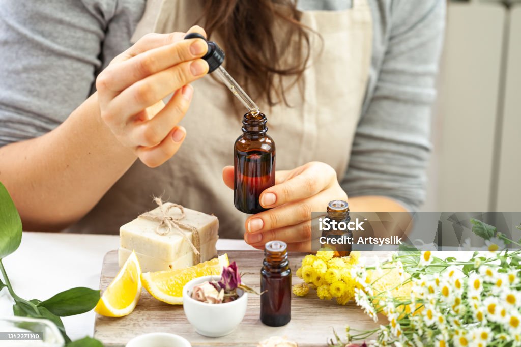 Woman performing professional cosmetics research. Concept of natural organic ingredients in dermatology. Essential oil, extract of herbs, fruits, vegetables. Natural moisturizing body, face care Essential Oil Stock Photo