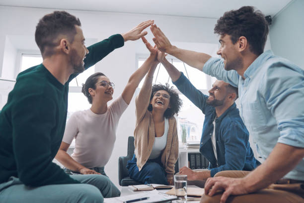 istock Confident young business team keeping hands clasped and smiling 1342271706