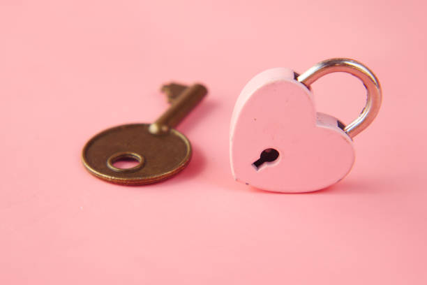 istock Pink Heart Shape Padlock And Key on table 1342273104