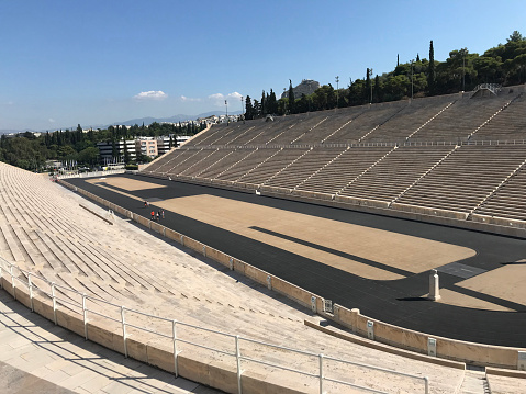 Athens, Greece - Jul 13, 2019: Symmetrical view of empty Panathenaic Stadium from the audience on sunny day. Panathenaic Stadium called Kallimarmaro in Athens. Taken on mobile device.
