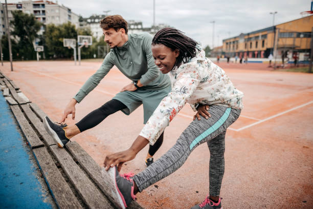 amigos fazem exercícios de aquecimento - couple stretching running jogging - fotografias e filmes do acervo