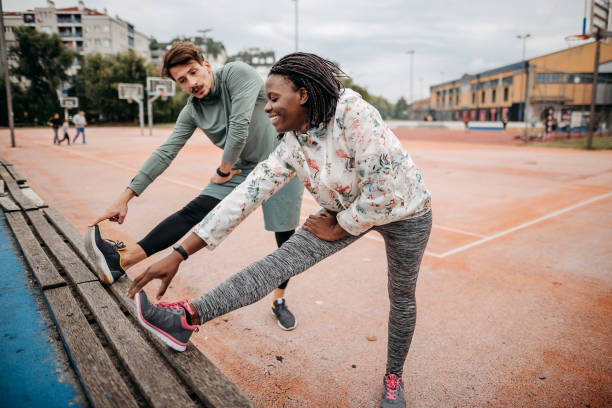 amigos fazem exercícios de aquecimento - couple stretching running jogging - fotografias e filmes do acervo